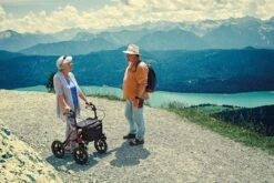 Dietz Taima XC Air Rollator Rot, Luftbereifung, Neues Modell, Leichtgewicht Nur 9,1 Kg, Bis 150kg Belastbar, Mit Gehstockhalter, Einkaufsnetz, Ankipphilfe, Reflektoren & Lenkungsdämpfer -Coloplast Verkaufsgeschäft DIETZ Bild Rollator TAiMAXC Berg 01 1200x800 1024x683 1