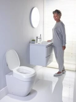 Toilettensitzerhöhung Aquatec AT 90 Ergo, HMV, Erhöht Den Toilettensitz Um 10 Cm, Mit Deckel, Passt Auf Alle Gängigen WC-Becken, Neues Design Ohne Schrauben Montierbar -Coloplast Verkaufsgeschäft index